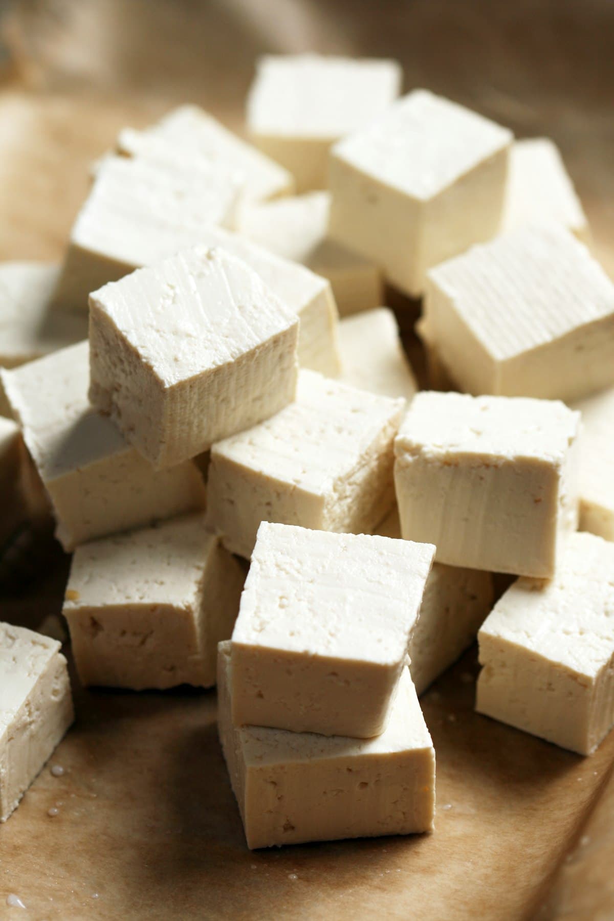 Freshly cut cubes of soft white paneer on a board