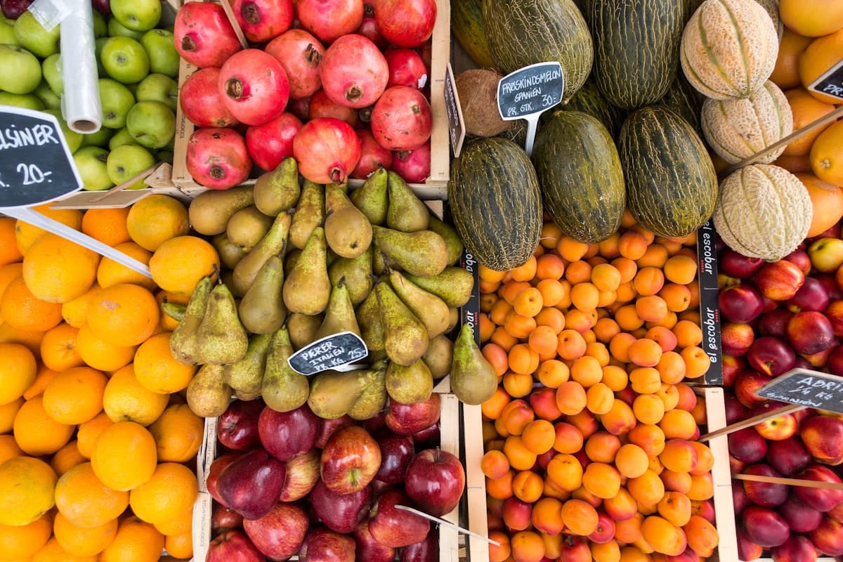 Crates of oranges, pears, pomegranates, apricots and melons at a fruit market